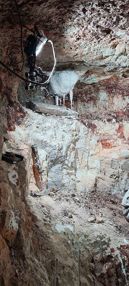 Underground excavation site with plastered specimen and lighting equipment